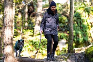 female dog walker hikes with adorable dog through Canadian mountains